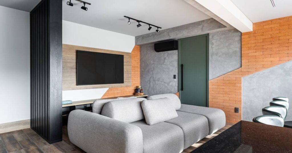 Apartamento urbano de 90 m² tem parede azul profundo na suíte e tijolinhos na sala