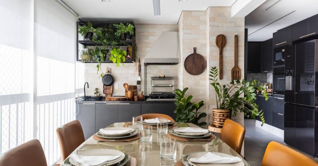 Biofilia e elegância: apartamento tem cozinha preta e muitas plantas na varanda