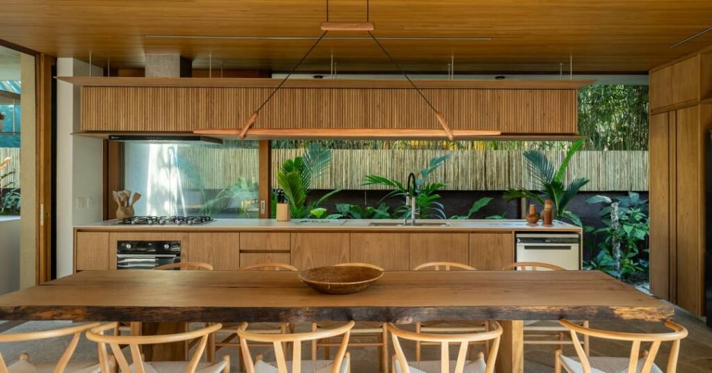 Casa tropical em Ubatuba tem cozinha aberta para o jardim