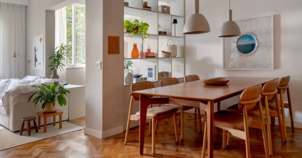 Estante vazada com nichos delimita sala de jantar neste apartamento de 100 m²