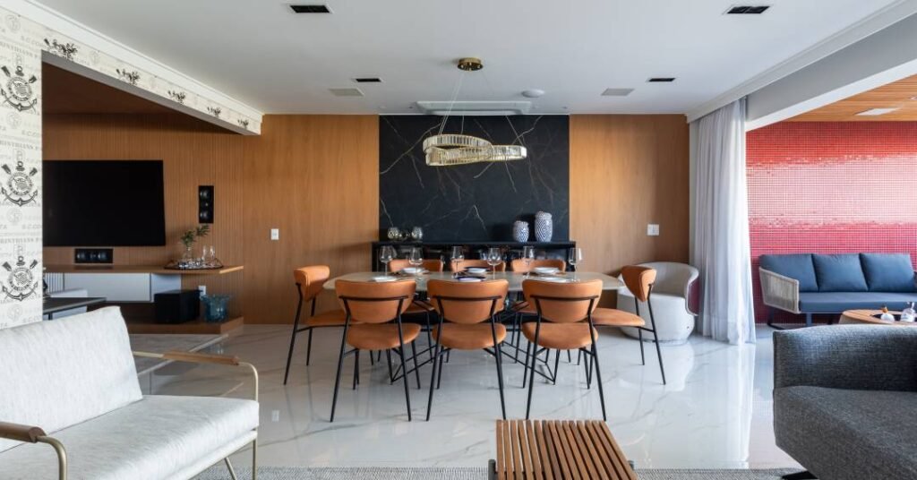 Apartamento elegante em tons sóbrios tem painel de madeira e pedra na sala de jantar