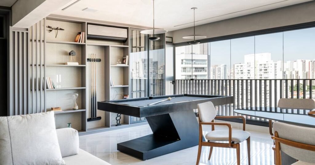 Apartamento sóbrio no Tatuapé tem living com vista para a cidade e mesa de sinuca