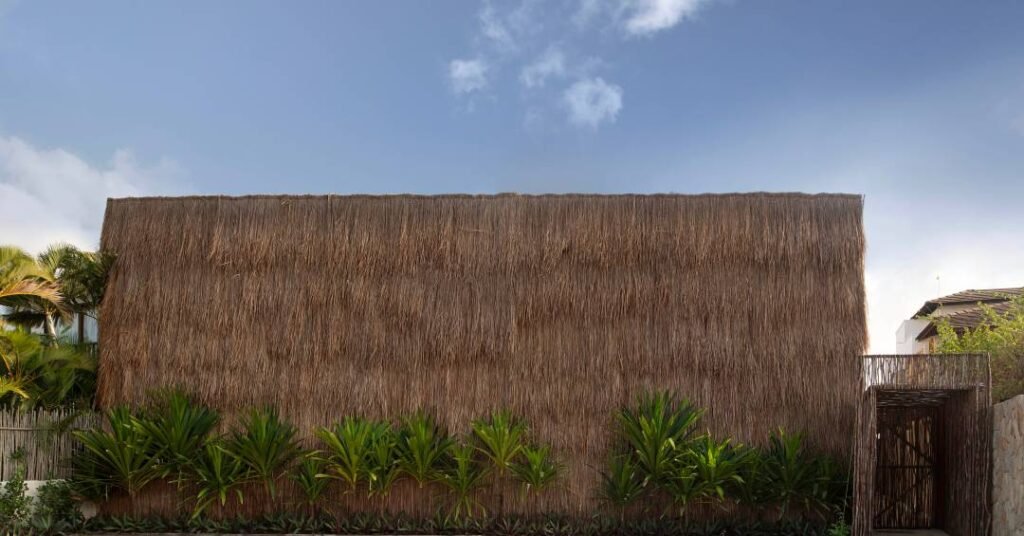 Casa de veraneio rústica em Alagoas tem fachada revestida integralmente em palha