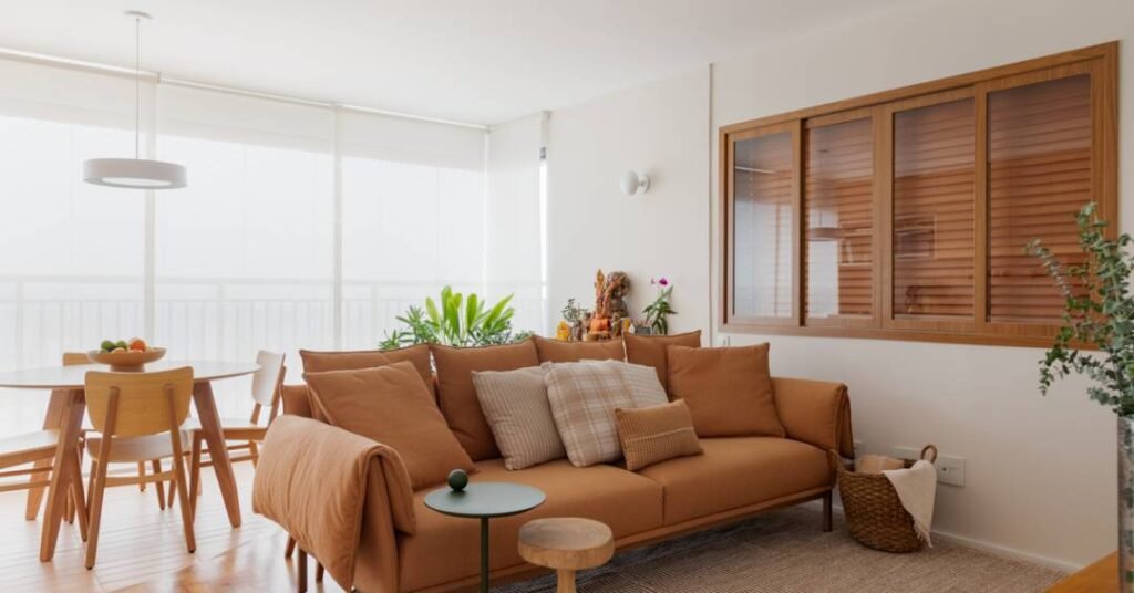 Apartamento de 79 m² com cara de casa tem tons terrosos leves e biblioteca íntima