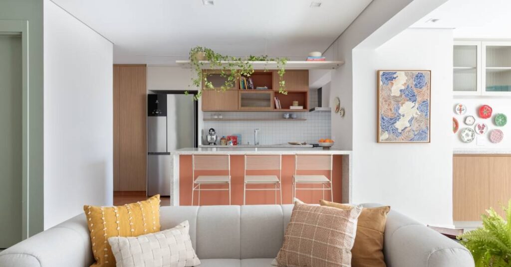 Apartamento leve e descontraído tem toques rosados no ladrilho e ilha da cozinha