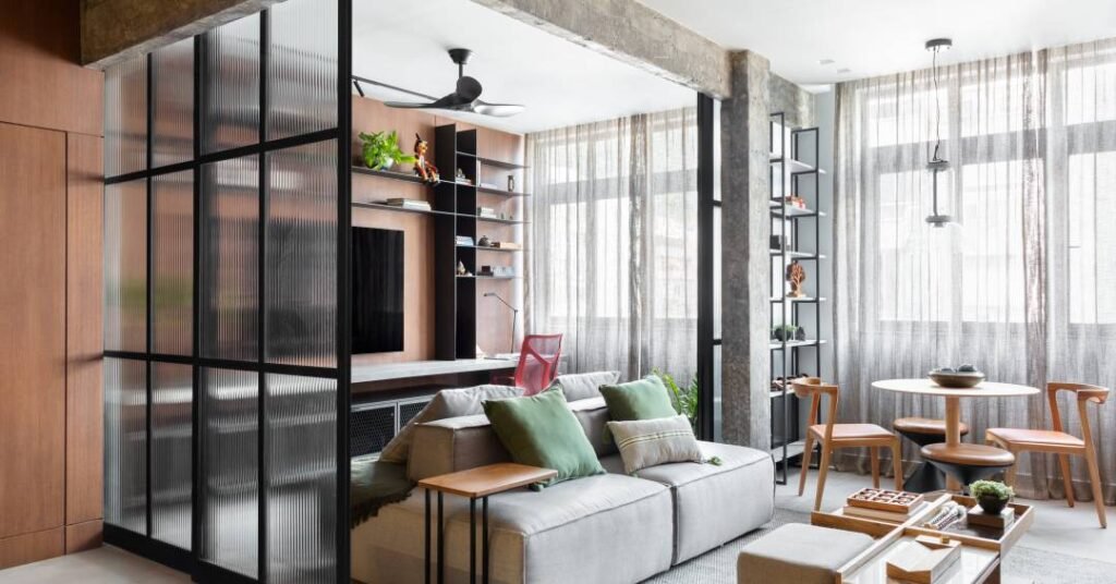 Apê vira loft com paleta de cinzas, madeiras profundas, estruturas metálicas e vigas aparentes