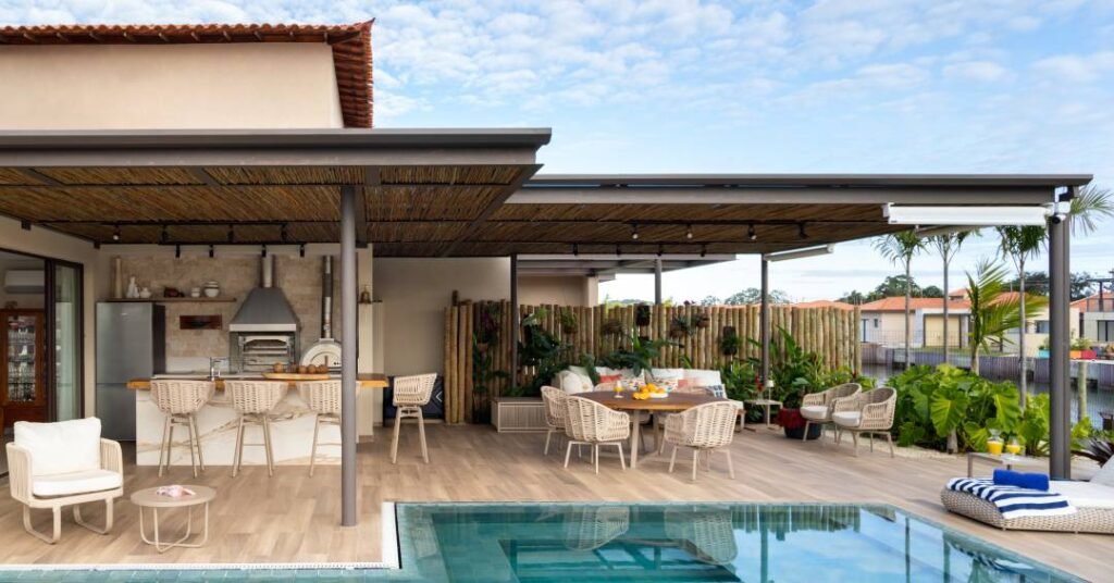 Pérgolas, porcelanatos em tom areia, pedras de seixos compõem esta casa de praia em Búzios