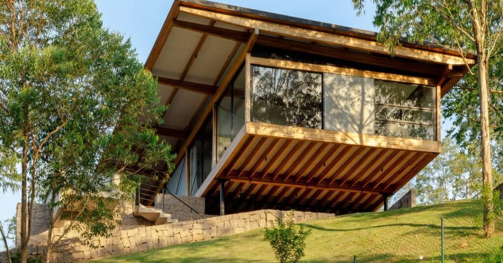 Casa em “pirambeira” fica suspensa em pilotis metálicos e mistura-se à paisagem