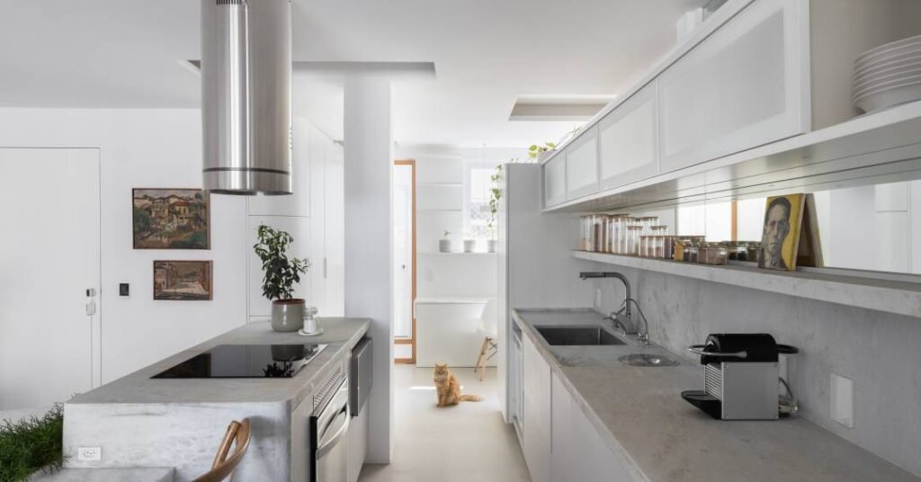 Neste apartamento de 97 m² a ilha de pedra se estende até se converter em mesa de jantar