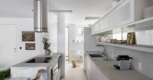 Neste apartamento de 97 m² a ilha de pedra se estende até se converter em mesa de jantar