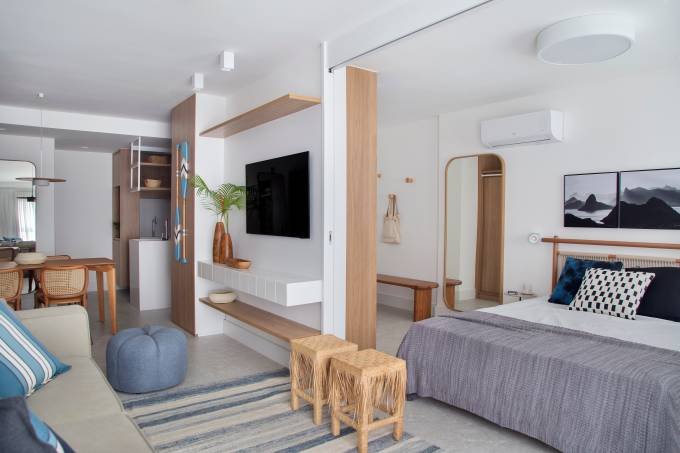 Leve e despretensioso: apê de 50 m² tem painel de azulejos em branco e azul-escuro na sala