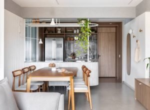 Apartamento de 100 m² em tons neutros tem painel deslizante em serralheria com vidro canelado na cozinha