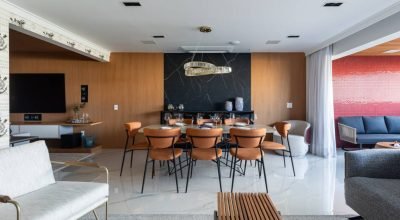 Apartamento elegante em tons sóbrios tem painel de madeira e pedra na sala de jantar