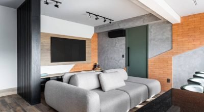 Apartamento urbano de 90 m² tem parede azul profundo na suíte e tijolinhos na sala