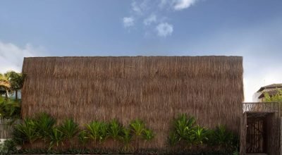 Casa de veraneio rústica em Alagoas tem fachada revestida integralmente em palha