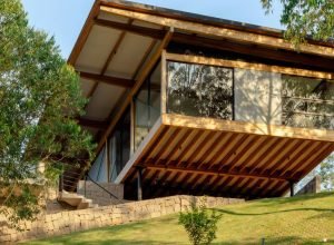 Casa em “pirambeira” fica suspensa em pilotis metálicos e mistura-se à paisagem