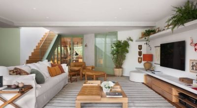 Cobertura tem jardim elevado no terraço e marcenaria verde elegante entre cozinha e sala