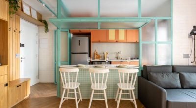 Divisória azul com vidro abriga balcão e divide cozinha e sala neste apê de 42 m²