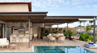 Pérgolas, porcelanatos em tom areia, pedras de seixos compõem esta casa de praia em Búzios