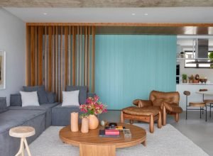 Porta de correr em laca verde separa (ou integra) sala e cozinha deste apartamento