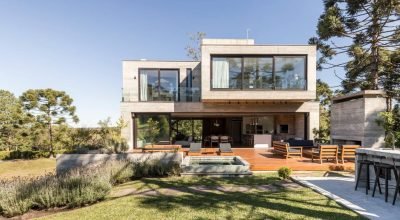 Três volumes de concreto sobrepostos de maneira assimétrica foram esta casa